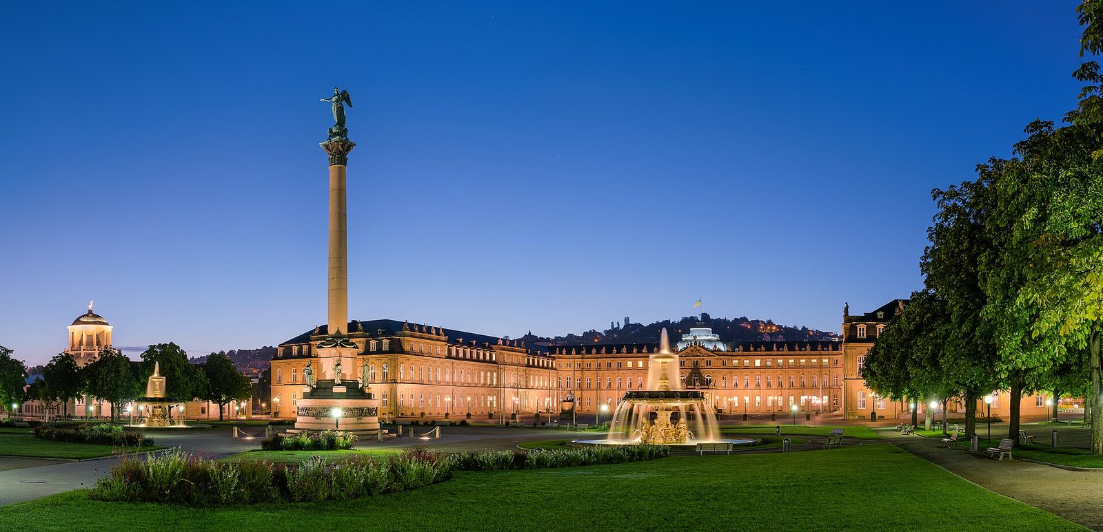 Stuttgarter Schlossplatz zur blauen Stunde mit Neuem Schloss, Jubiläumssäule und beleuchtetem Springbrunnen