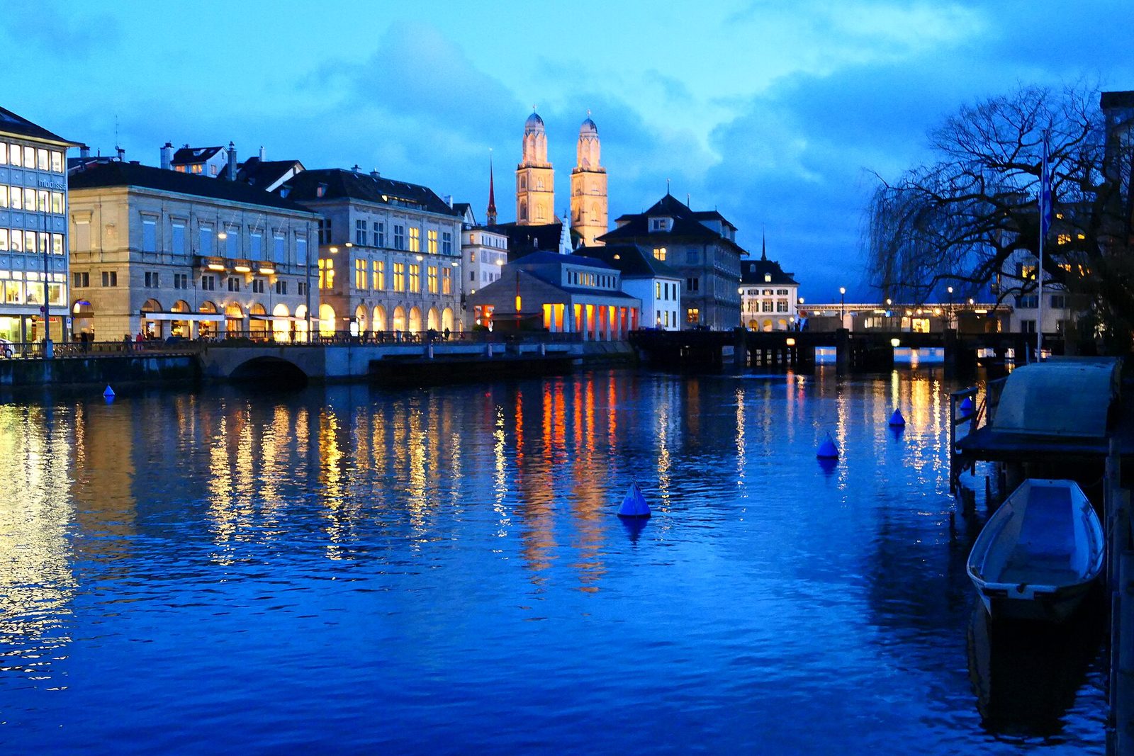 Zürcher Altstadt an der Limmat zur blauen Stunde mit den beleuchteten Türmen des Grossmünsters